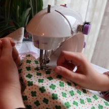 Candela practica la costura en su casa con su pequeña máquina de coser